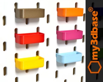 May include: Five small plastic storage bins in different colors, mounted on a white pegboard wall. The bins are brown, orange, pink, light blue, and yellow.