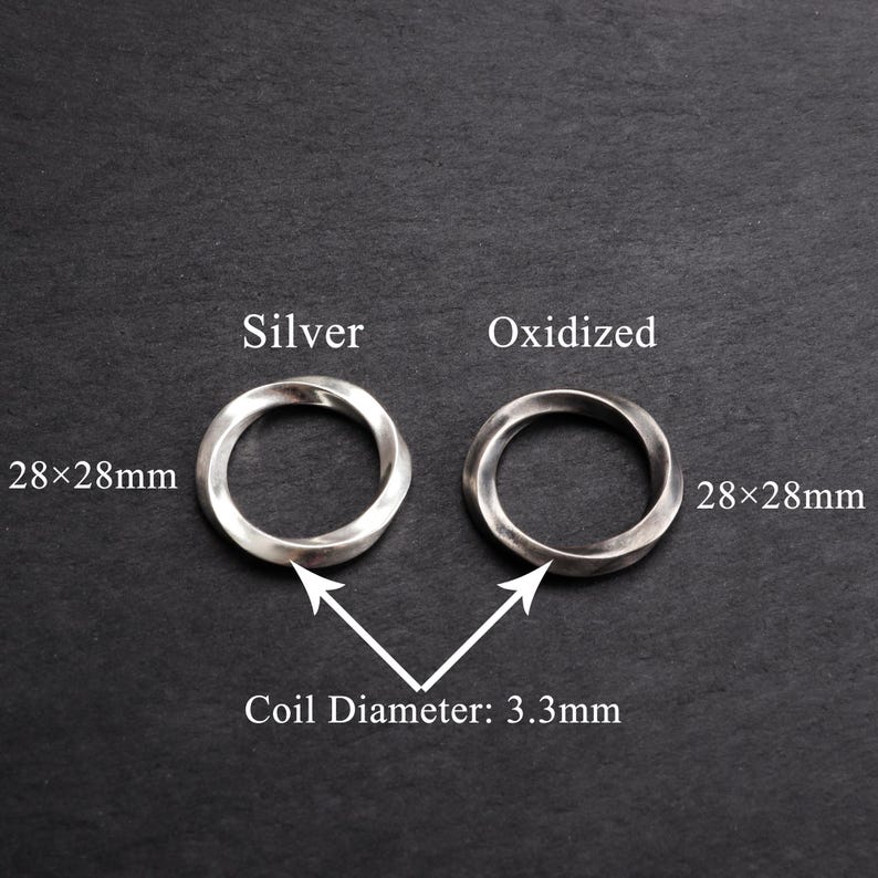 May include: Two silver rings, one polished and one oxidized, each measuring 28x28mm. The coil diameter is 3.3mm. The rings are displayed on a dark gray surface, with text labels indicating their finish.