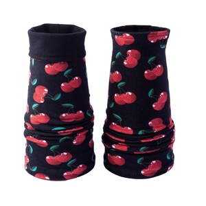 Könnte beinhalten: Zwei schwarze Armstulpen mit einem sich wiederholenden Muster aus roten Kirschen und grünen Blättern. Die Armstulpen haben einen gefalteten Bund oben und sind am Handgelenk gerafft. Der Hintergrund ist weiß.