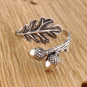 May include: A silver ring with an oak leaf and two acorns. The ring is adjustable and can be worn on any finger.