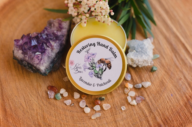 Ninas Bees Restoring Hand Balm is a honey colour, highly fragrant beeswax balm in a golden aluminium tin.  "Indulge in the beauty of eco-friendly skincare. Nina’s Bees Restoring Hand Balm: the perfect blend of nature and luxury