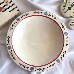 Op de afbeelding: Een set van drie keramische mokken met een gespikkelde, matte afwerking. De mokken zijn in crème, lichtgrijs en donkergrijs. Elke mok heeft een eenvoudig, minimalistisch ontwerp.