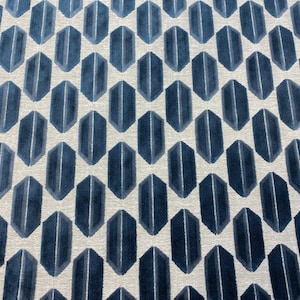 May include: A white rug with a repeating pattern of dark blue geometric shapes. The shapes are elongated hexagons with a vertical line down the center.