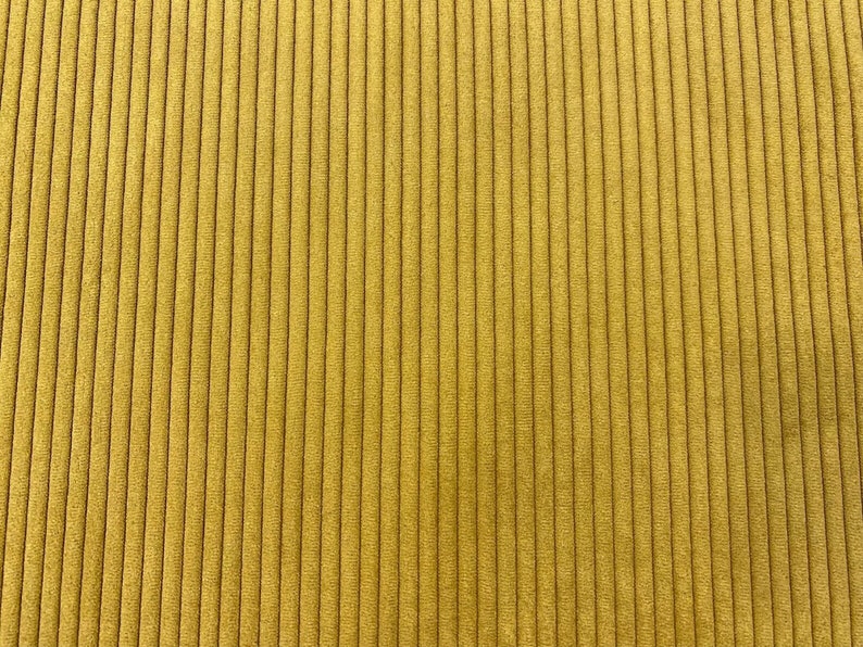 K&ouml;nnte beinhalten: Nahaufnahme eines gelben Cordstoffs mit vertikaler Rippenstruktur.