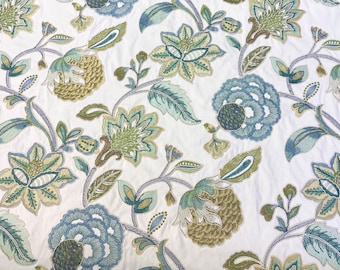 May include: White fabric with an embroidered floral pattern in shades of blue and green. The design features large, stylized flowers and leaves.