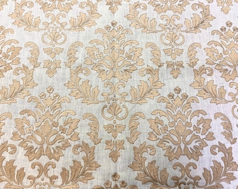 May include: A white fabric with a gold damask pattern. The pattern features intricate floral designs and swirls.