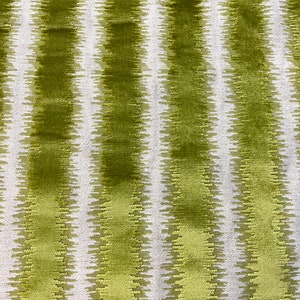 May include: A fabric featuring a repeating pattern of vertical stripes in shades of olive green and white. The green stripes have a textured, jagged edge, while the white stripes appear as a smooth, solid background between the green sections.
