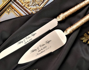 May include: Gold wedding cake knife and server set with engraved names and wedding date. The text reads "Ashley & Colin Tappin July 16, 2023" and "Ashley & Colin Tappin July 16, 2023 1 Corinthians 13:4-5".