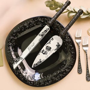 May include: A black cake serving set with a decorative floral and skull design. The set includes a cake knife and server, with the words "Till death" and "Dylan & Courtney" printed on them. The set is on a black plate with matching forks.