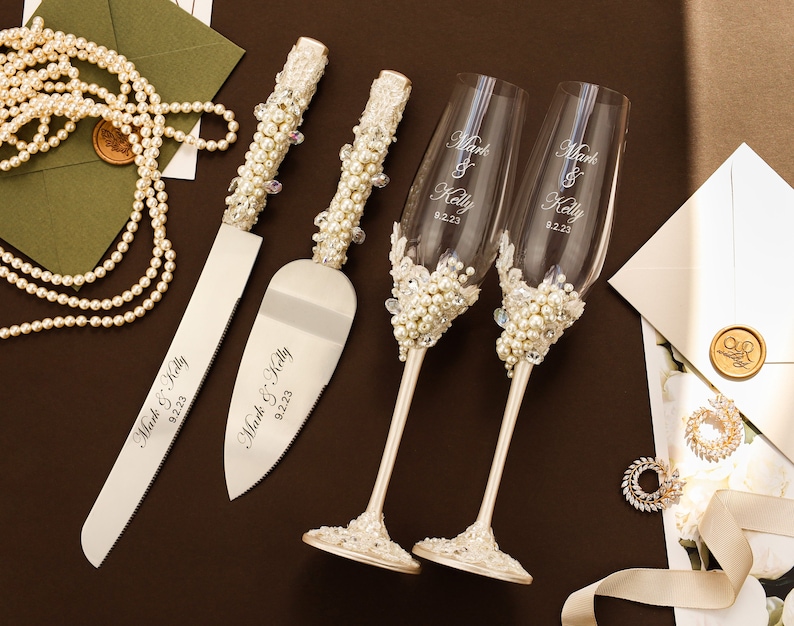 Copas de boda con perlas, juego de cuchillos para cortar pasteles, regalo de despedida de soltera en color marfil para la novia y el novio, copas de champán grabadas con decoración rústica de encaje. Flutes and cake set