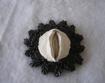 Sculpted Vulva in a Round Black Composite Frame With Etched Holly Leaves and Berries 177