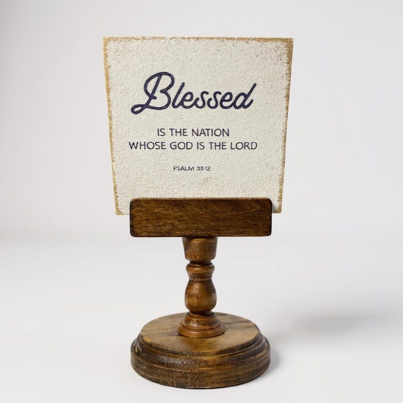 Rustic wooden pedestal display stand with a small metal clip holding a blank card for photo display, note, or wedding table number.