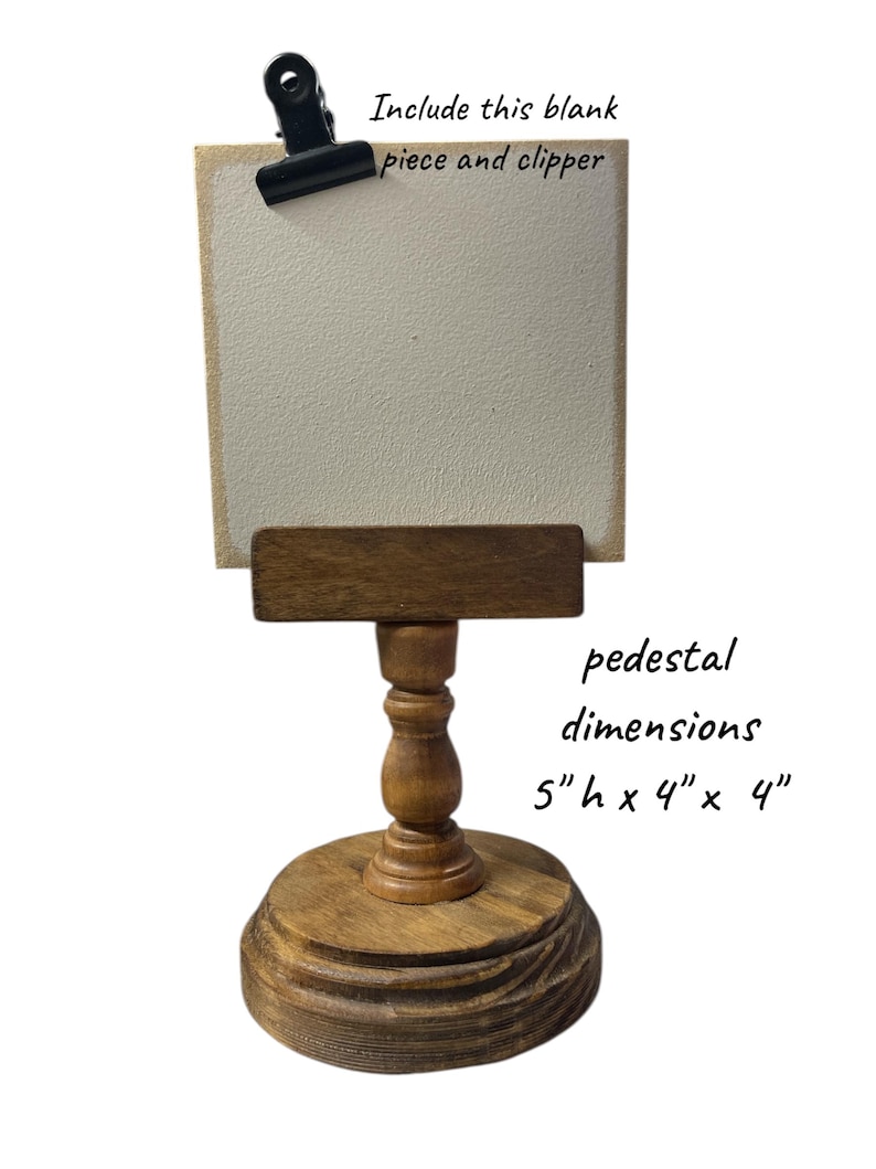 Rustic wooden pedestal display stand with a small metal clip holding a blank card for photo display, note, or wedding table number.