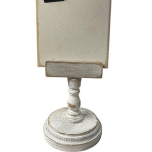 Rustic wooden pedestal display stand with a small metal clip holding a blank card for photo display, note, or wedding table number.