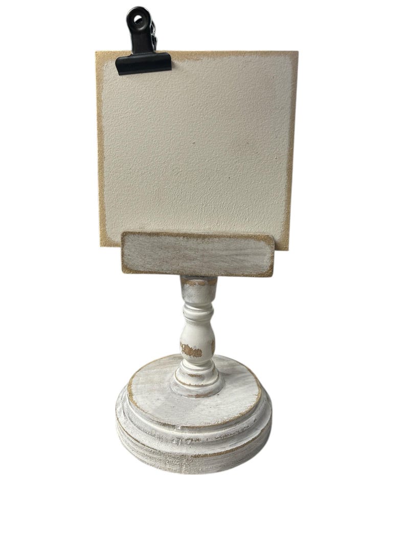 Rustic wooden pedestal display stand with a small metal clip holding a blank card for photo display, note, or wedding table number.