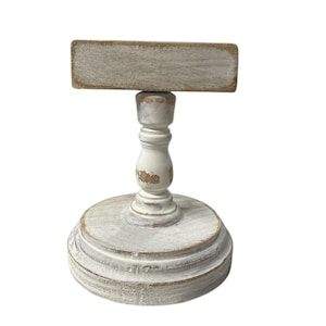 Rustic wooden pedestal display stand with a small metal clip holding a blank card for photo display, note, or wedding table number.
