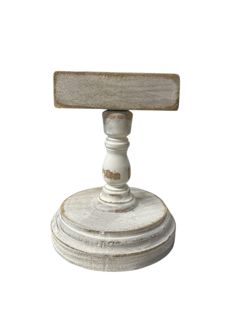 Rustic wooden pedestal display stand with a small metal clip holding a blank card for photo display, note, or wedding table number.