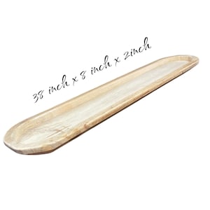 May include: A long, light-colored wooden tray with rounded ends. The tray measures 38 inches long, 8 inches wide, and 2 inches deep. The text on the image reads: 38 inch x 8 inch x 2 inch.
