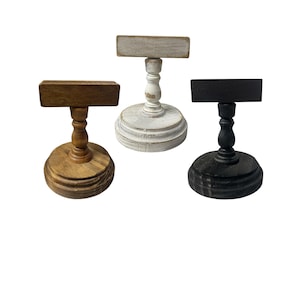 Rustic wooden pedestal display stand with a small metal clip holding a blank card for photo display, note, or wedding table number.