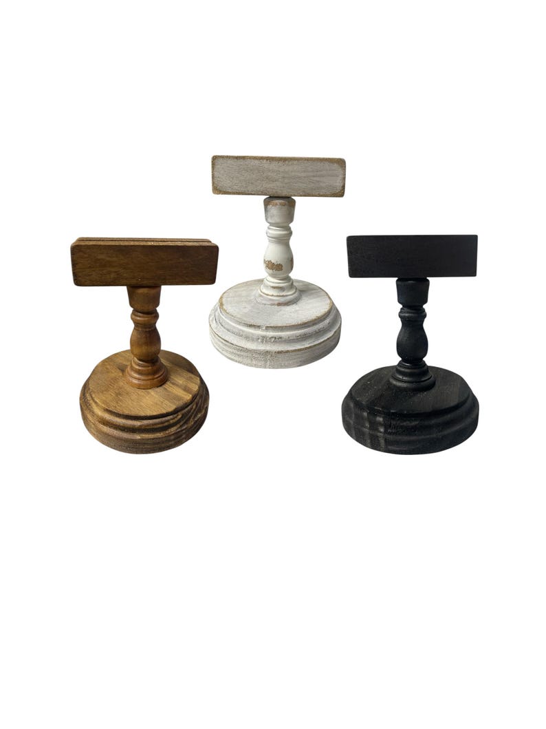 Rustic wooden pedestal display stand with a small metal clip holding a blank card for photo display, note, or wedding table number.