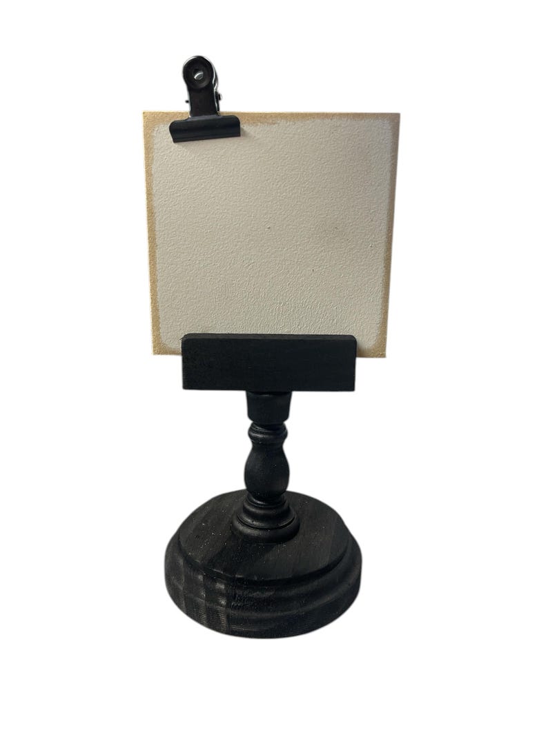 Rustic wooden pedestal display stand with a small metal clip holding a blank card for photo display, note, or wedding table number.
