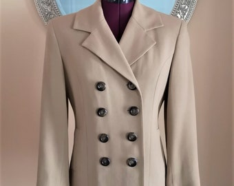 Könnte beinhalten: Ein beigefarbener Blazer mit doppeltem Knopfverschluss und schwarzen Knöpfen.