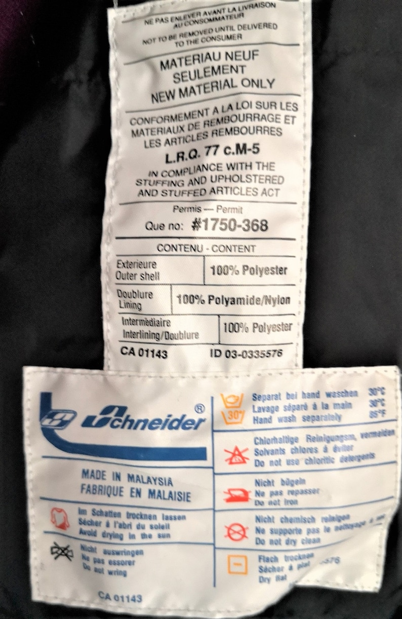 Puede incluir: Etiqueta blanca con texto negro que detalla la composici&oacute;n del material de una chaqueta. La etiqueta dice "Material Neuf Seulement" y "New Material Only". La etiqueta tambi&eacute;n incluye instrucciones de cuidado para lavar, secar y planchar la chaqueta. La etiqueta est&aacute; unida a una chaqueta negra.