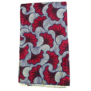 Peut inclure: Tissu plié avec un motif floral répétitif. Le motif présente de grandes fleurs rouges stylisées avec des centres noirs et des lignes rayonnantes blanches et bleues sur un fond crème. Le tissu est plié et prêt à l'emploi.