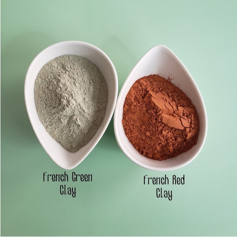 May include: Two white bowls filled with powder. The bowl on the left contains green powder labeled "French Green Clay". The bowl on the right contains red powder labeled "French Red Clay".