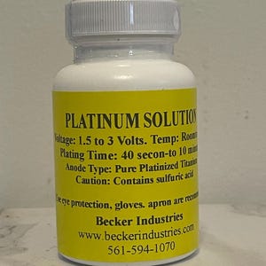 May include: A white plastic bottle with a yellow label that reads "PLATINUM SOLUTION". The label also includes instructions for use, safety precautions, and contact information for Becker Industries.