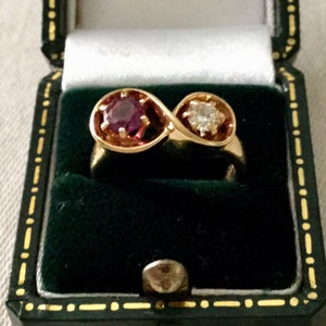 Peut inclure: Une bague en or avec un rubis et un diamant sertis dans un design infini.