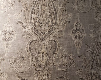 May include: A close-up of a gray and white paisley patterned fabric. The fabric has a subtle sheen and a textured surface.