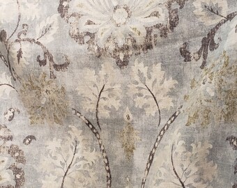 May include: A close-up of a fabric with a light blue background and a brown and white floral pattern.