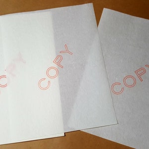 May include: Three white sheets of paper with the word "COPY" printed in red on each sheet.