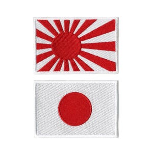 May include: Two embroidered patches depicting the Japanese flag. One shows a red sun with rays on a white background. The other displays a red circle on a white background, representing the national flag.