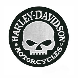 May include: A round, black Harley-Davidson patch with white embroidered text and a skull design. The text reads "HARLEY-DAVIDSON MOTORCYCLES" around the edge, with a skull in the center.