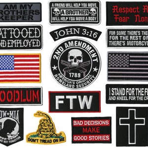 Puede incluir: Una colección de parches bordados con varios diseños y texto. Los parches incluyen una bandera estadounidense, una calavera con armas cruzadas y frases como "I AM MY BROTHERS KEEPER" y "TATTOOED AND EMPLOYED".