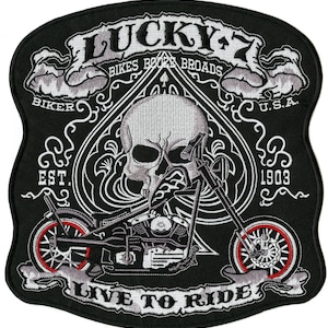 May include: Black embroidered patch with a skull, motorcycle, and the text "LUCKY 7 BIKES BOOZE BROADS" and "LIVE TO RIDE". The design includes a spade shape and the text "U.S.A." and "EST. 1903". The motorcycle wheels have red accents.