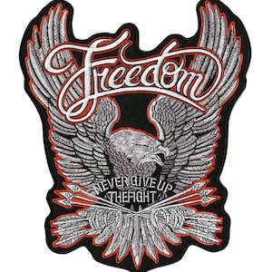 May include: Embroidered patch featuring a detailed eagle with outstretched wings, the word "Freedom" in white script, and the phrase "Never Give Up The Fight." The design includes arrows and a red border.