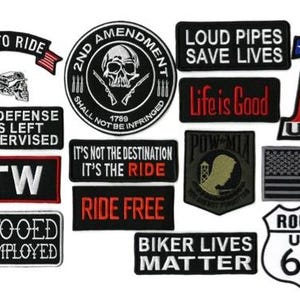 May include: A collection of embroidered patches with various designs and text. Patches include phrases like "Live to Ride," "2nd Amendment," "Life is Good," and "Biker Lives Matter." The patches feature a mix of colors and styles.
