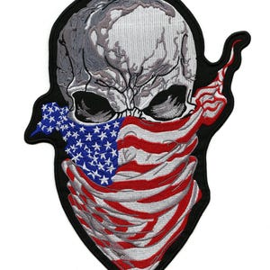 Pode incluir: Patch bordado com uma caveira usando uma bandana da bandeira americana. A caveira é cinza e branca, com órbitas oculares pretas. A bandana exibe as estrelas e listras da bandeira dos EUA. O patch tem uma borda preta.