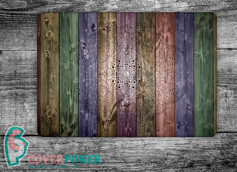 May include: A colorful wood background with a mandala design in black and white. The wood planks are painted in shades of green, blue, purple, brown, and pink.