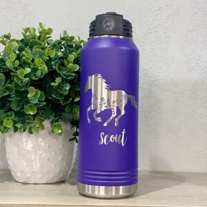 May include: Purple stainless steel water bottle with a silver horse design and the word "Scout" engraved on the side.