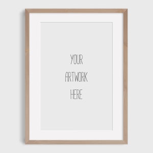 Op de afbeelding: Een licht houten fotolijst met een witte passe-partout en de tekst "YOUR ARTWORK HERE" in het midden.
