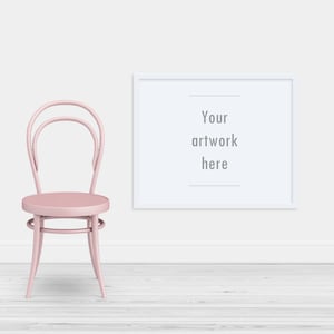 Könnte beinhalten: Ein rosa Holzstuhl mit abgerundeter Sitzfläche und weißem Rahmen steht vor einer weißen Wand, an der ein weißer Rahmen hängt. Der Rahmen enthält den Text "Your artwork here".