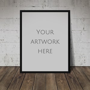 Può includere: Una cornice nera con un passepartout bianco e il testo "YOUR ARTWORK HERE" su uno sfondo di muro di mattoni bianchi.