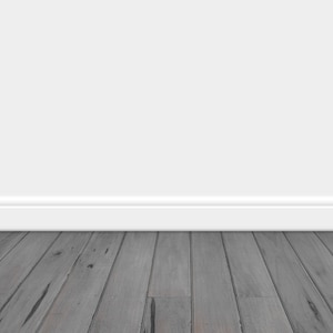Op de afbeelding: Een witte muur met een witte plint en een grijze houten vloer.