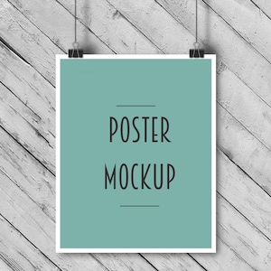 Puede incluir: Una maqueta de p&oacute;ster enmarcada en blanco colgada sobre un fondo de madera blanca. El p&oacute;ster tiene un fondo azul claro con el texto "POSTER MOCKUP" en negro.