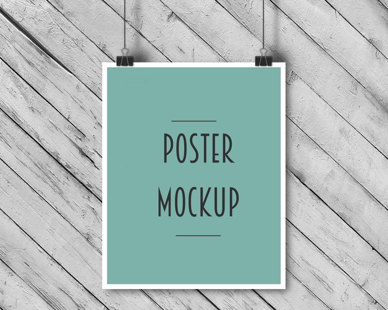 Puede incluir: Una maqueta de p&oacute;ster enmarcada en blanco colgada sobre un fondo de madera blanca. El p&oacute;ster tiene un fondo azul claro con el texto "POSTER MOCKUP" en negro.