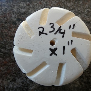 May include: White ceramic sanding disc with a 2 3/4" diameter and a 1" hole in the center. The disc has a starburst pattern with 10 points.